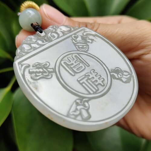 une main tenant un pendentif