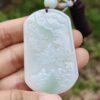 Una mano sosteniendo un colgante de jade.