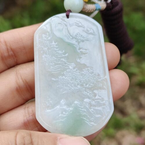 Una mano sosteniendo un colgante de jade.