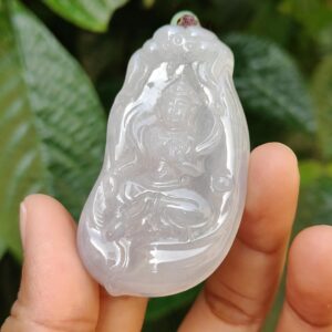 a hand holding a white jade object
