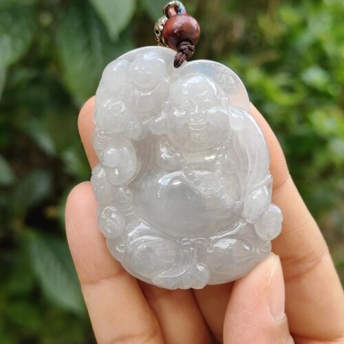 a hand holding a jade pendant