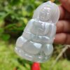 a hand holding a jade pendant