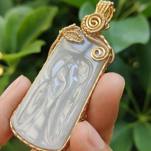 एक हाथ में पेंडेंट पकड़े हुए