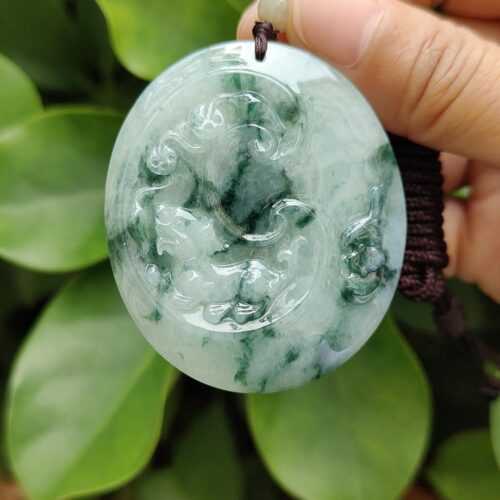 एक हाथ में जेड पेंडेंट थामे हुए