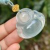 Una mano sosteniendo un colgante de jade.