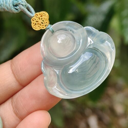 Una mano sosteniendo un colgante de jade.
