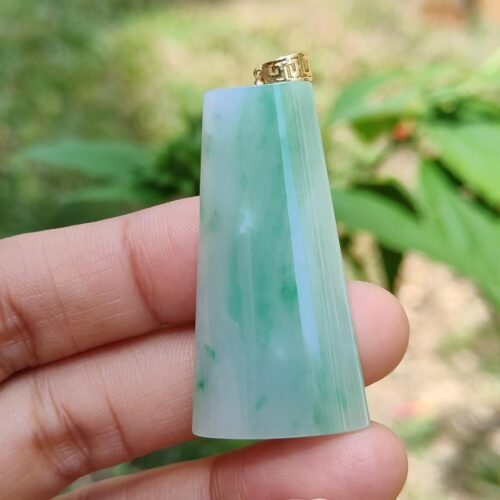 Una mano sosteniendo un colgante de jade.