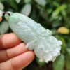 a hand holding a jade pendant