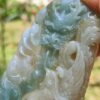 a hand holding a jade carving