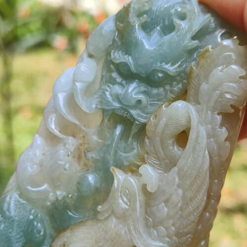 a hand holding a jade carving