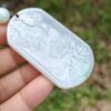Una mano sosteniendo un colgante de jade.