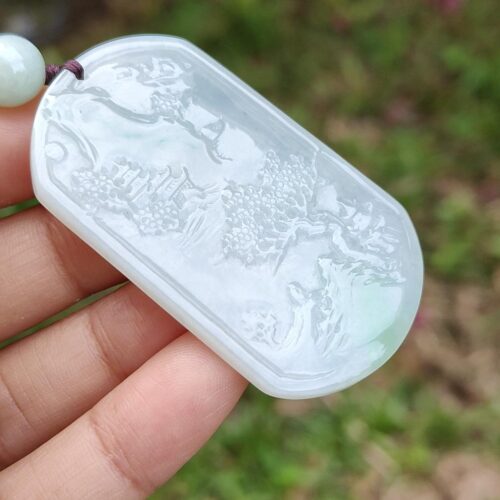 Una mano sosteniendo un colgante de jade.