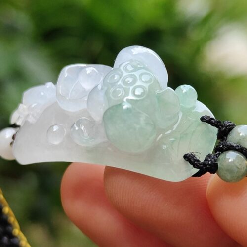 Una mano sosteniendo un colgante de jade.