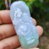 a hand holding a jade pendant