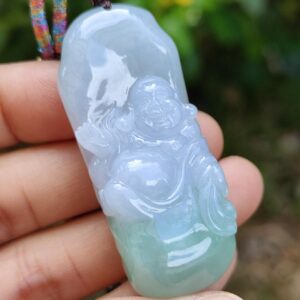 a hand holding a jade pendant