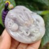 Una mano sosteniendo un colgante de jade.