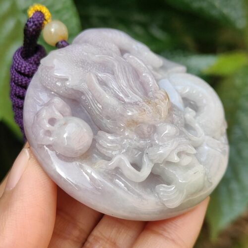Una mano sosteniendo un colgante de jade.