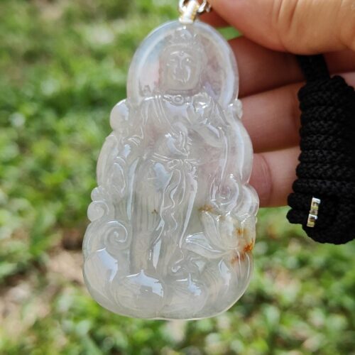 एक हाथ में जेड पेंडेंट थामे हुए