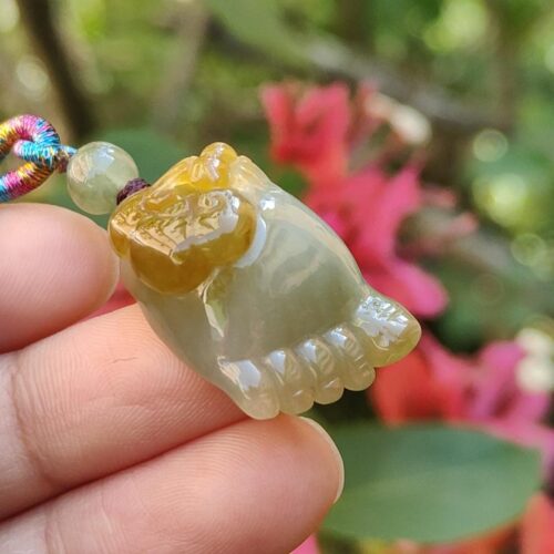 Una mano sosteniendo un colgante de jade.