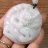 Una mano sosteniendo un colgante de jade.