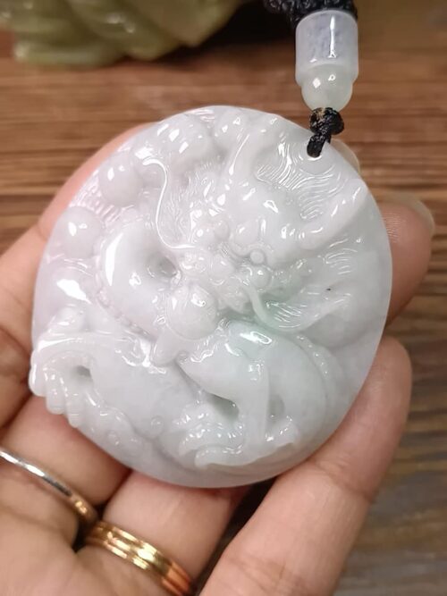 Una mano sosteniendo un colgante de jade.