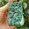 Una mano sosteniendo un colgante de jade.