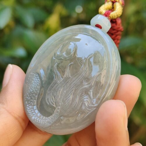 Una mano sosteniendo un colgante de jade.