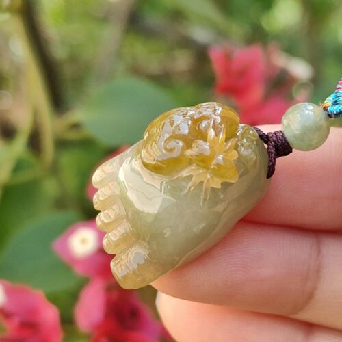 Una mano sosteniendo un colgante de jade.