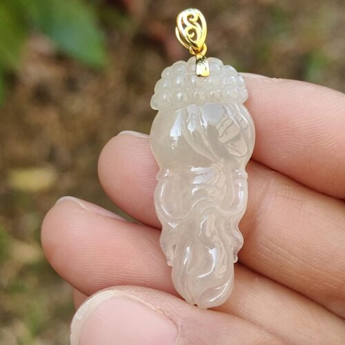 Una mano sosteniendo un colgante de jade.