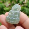 a person holding a jade pendant