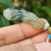 một bàn tay cầm một chiếc vòng cổ ngọc bích