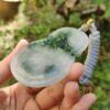 Una mano sosteniendo un colgante de jade.