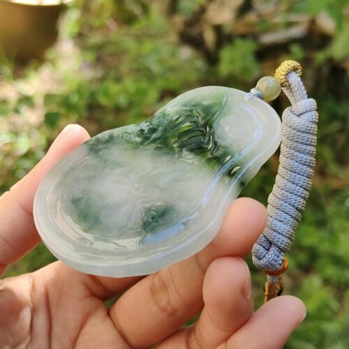 Una mano sosteniendo un colgante de jade.