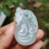 Una mano sosteniendo un colgante de jade.