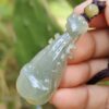 翡翠のペンダントを持つ手