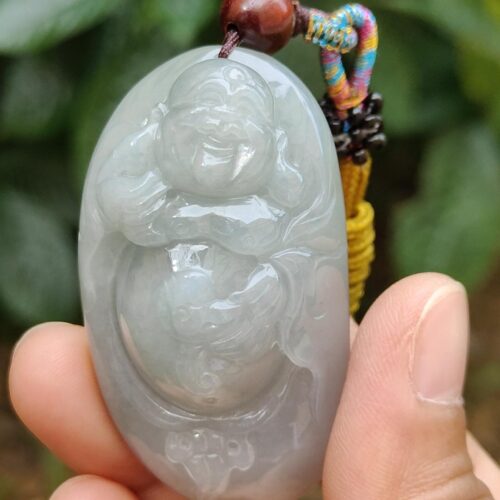 a hand holding a jade pendant
