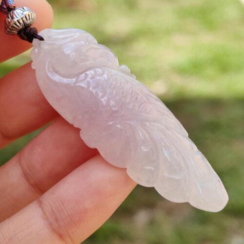Una mano sosteniendo un colgante de jade.