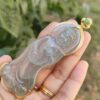 Una mano sosteniendo un colgante de jade.