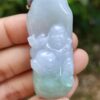 a hand holding a jade pendant