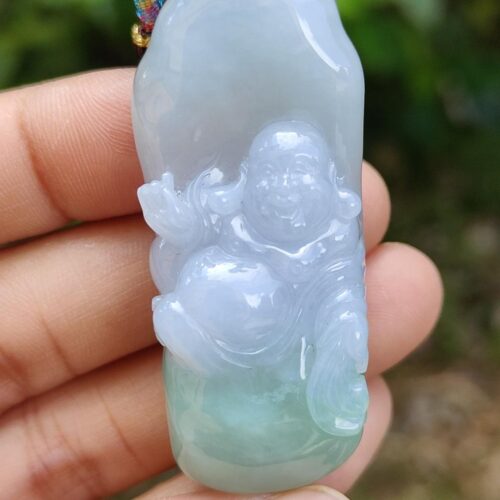 a hand holding a jade pendant