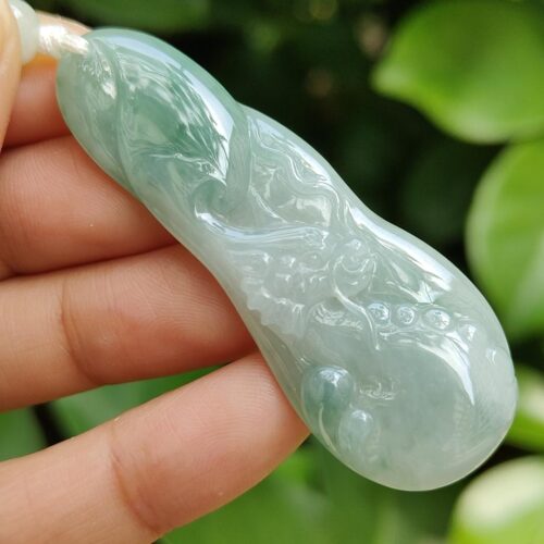 a hand holding a jade pendant