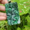 Una mano sosteniendo un colgante de jade.