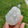 a hand holding a jade pendant