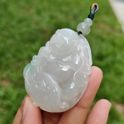 a hand holding a jade pendant