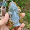 Una mano sosteniendo un colgante de jade.