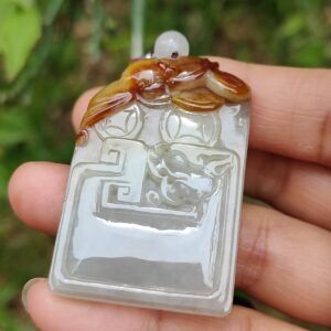 a hand holding a jade pendant