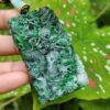 Una mano sosteniendo un colgante de jade.