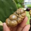 Una mano sosteniendo un colgante de piedra.
