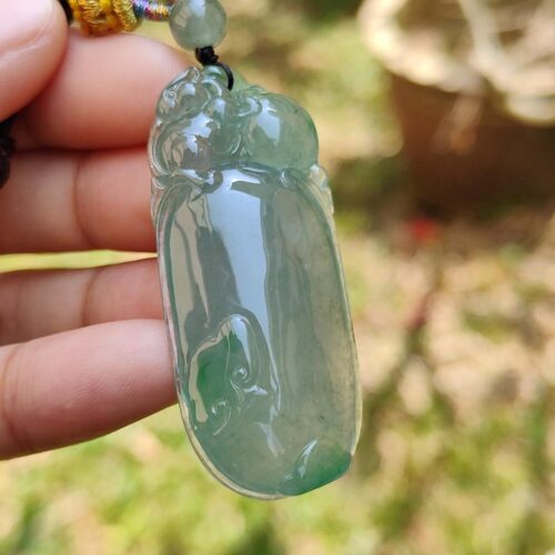 Una mano sosteniendo un colgante de jade.