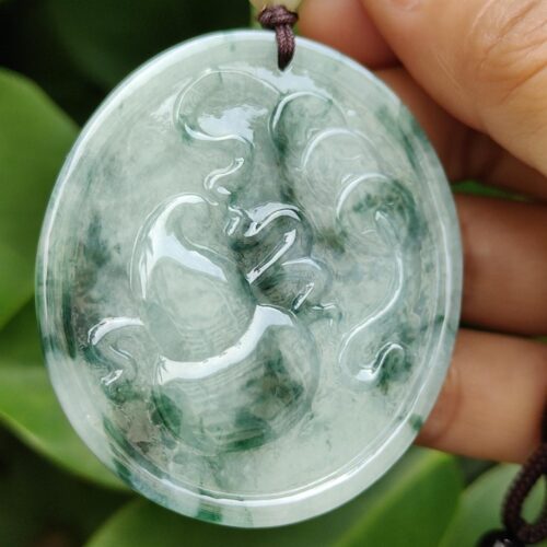 एक हाथ में जेड पेंडेंट थामे हुए